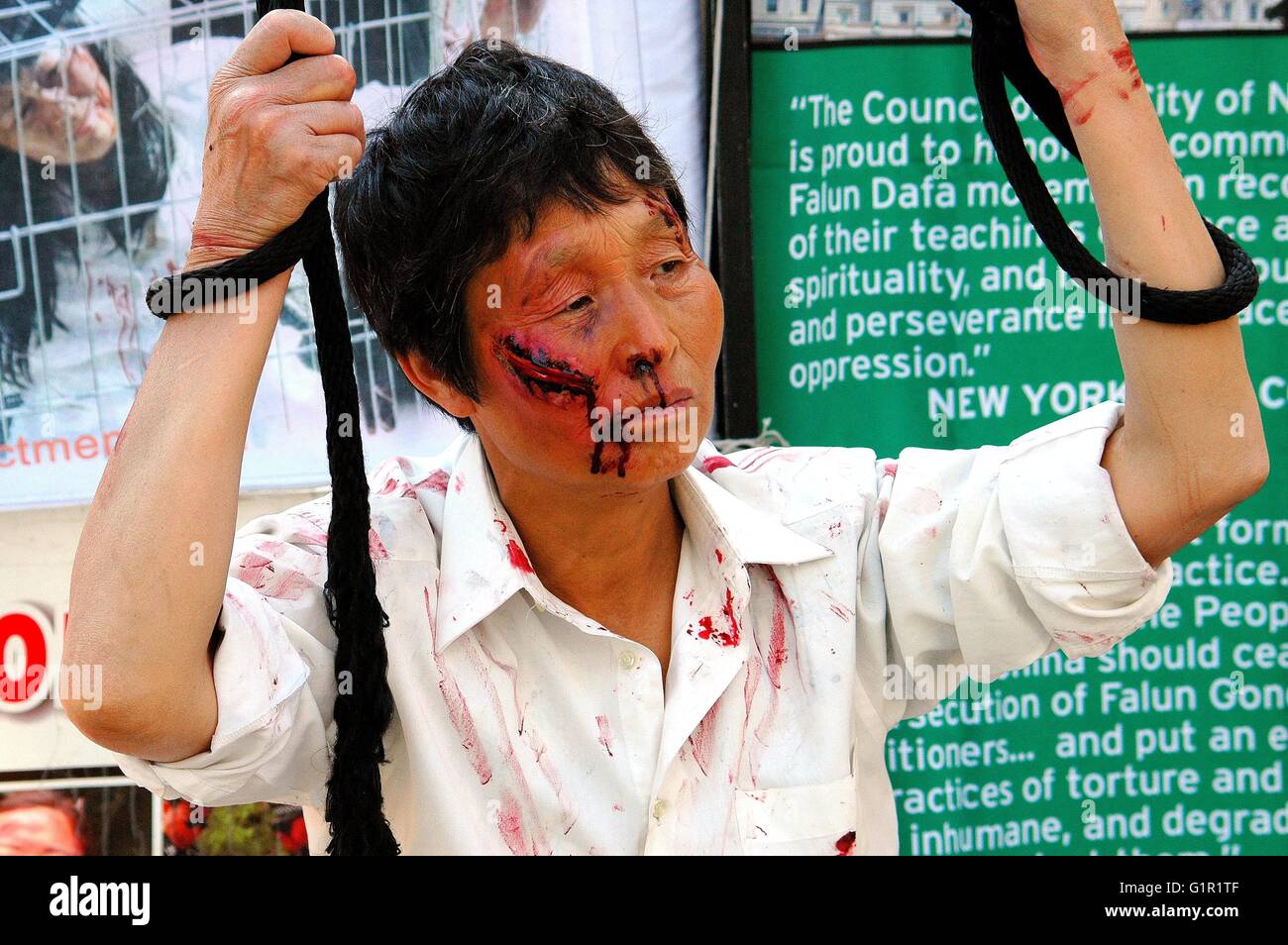 New York City:  Chinese woman wearing stage makeup simulating wounds and blood at a Falun Gong protest demonstration Stock Photo
