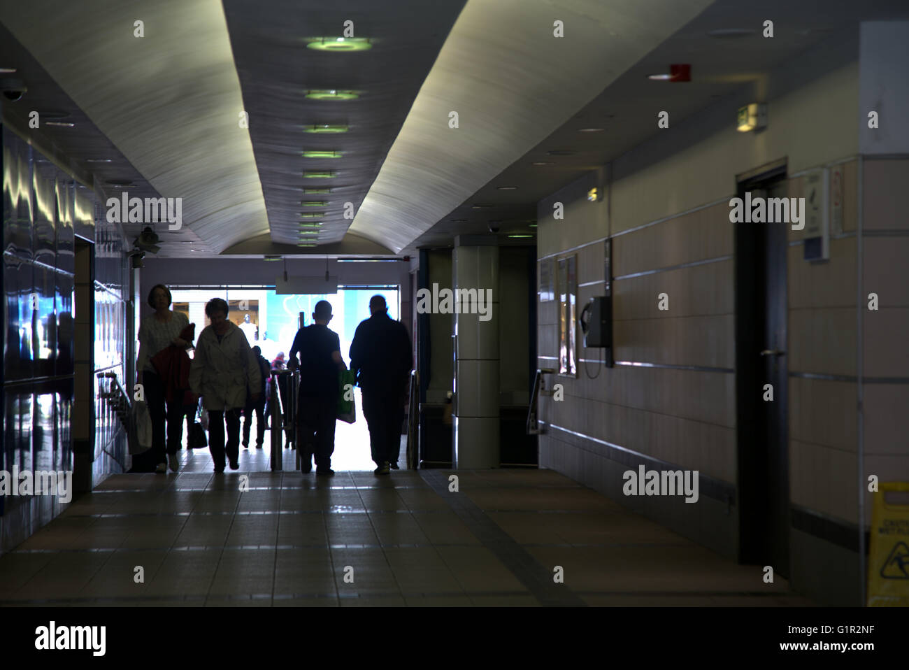 silhouetted people in subway entrance tunnel  with vanishing point,Glasgow, Scotland, UK Stock Photo