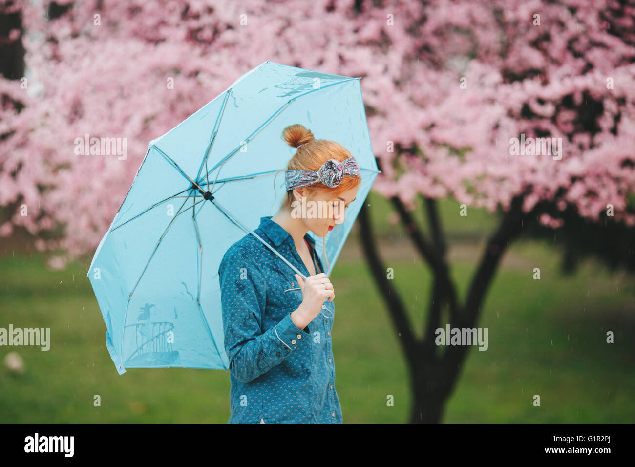 Young woman holding blue umbrella Stock Photo Alamy