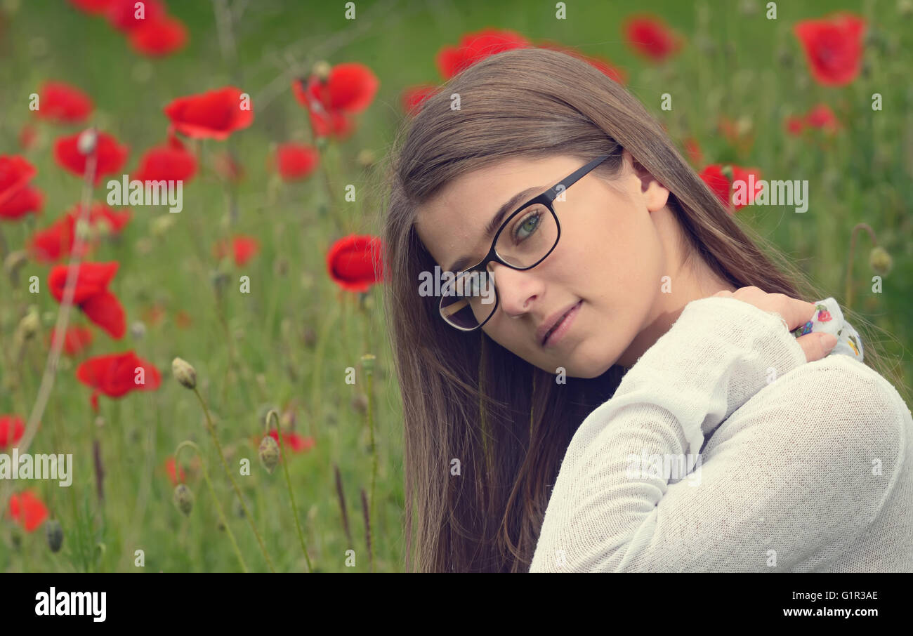 Portrait of young girl in poppy flowers field Stock Photo