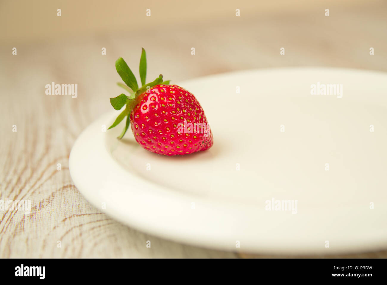 Ripe red strawberry on a white plate Stock Photo - Alamy