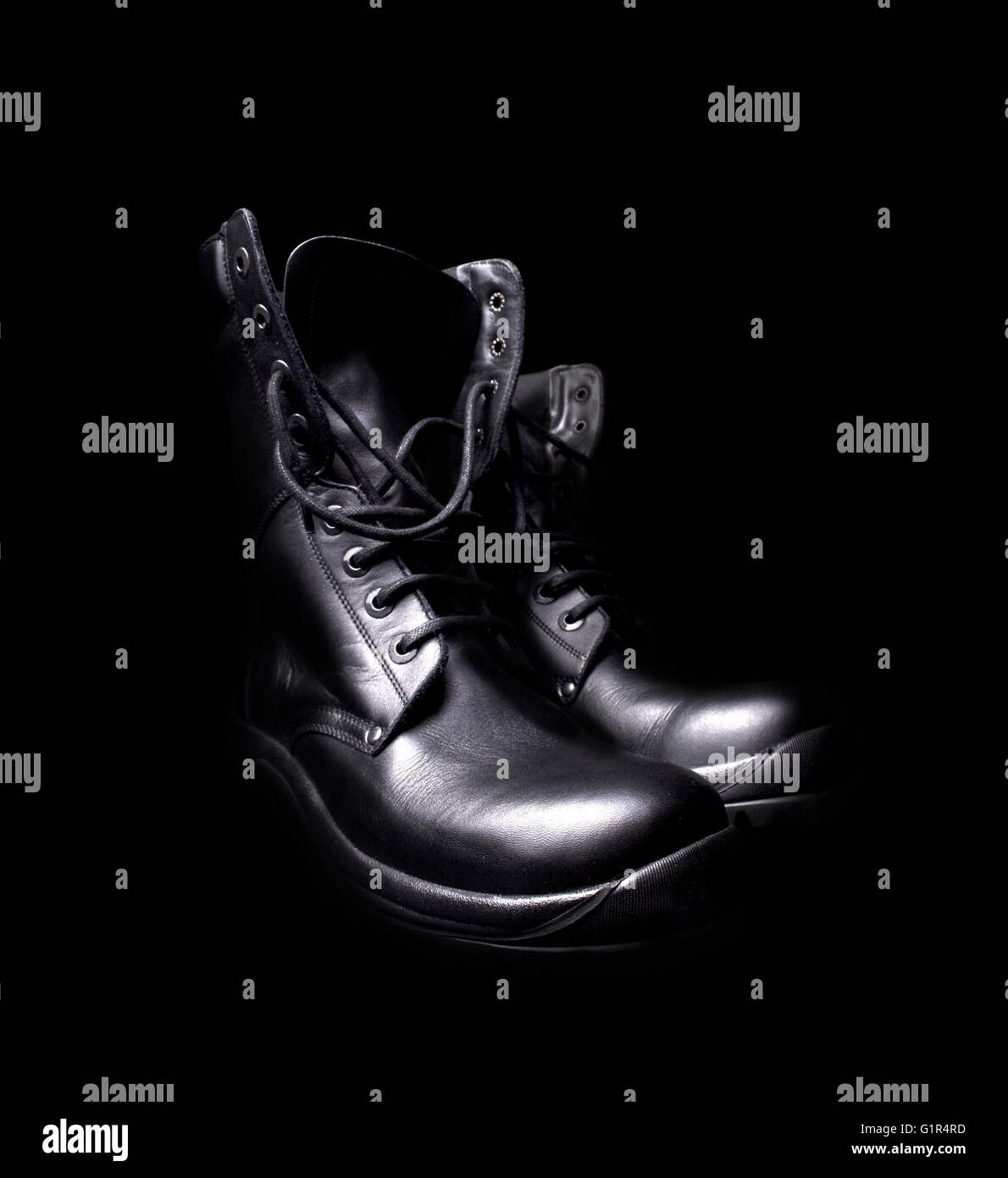 side view of a pair of shiny black leather boots with untied shoe laces
