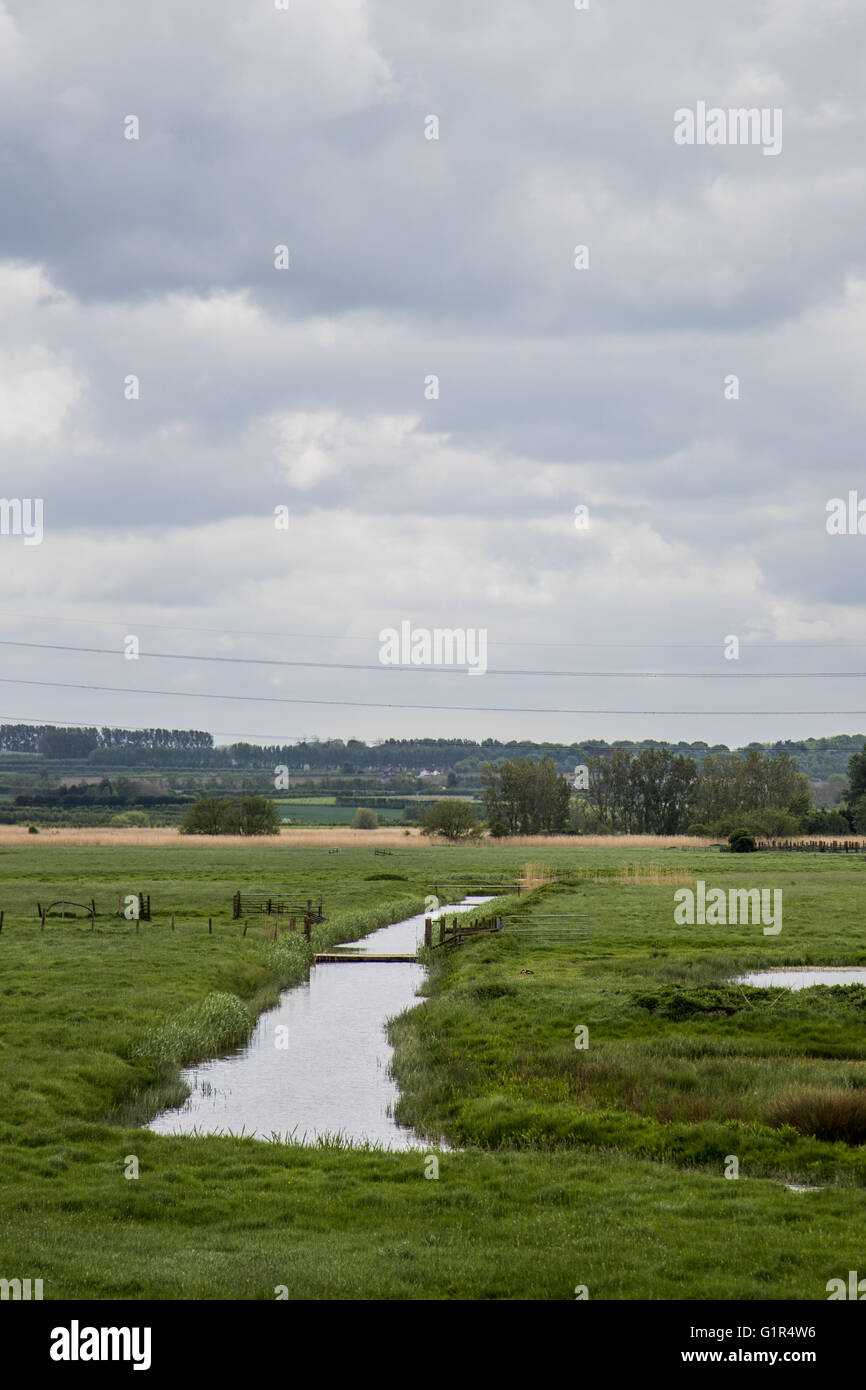 Creek leading towards the River Swale across Kent farmland, North Downs in the background Stock Photo