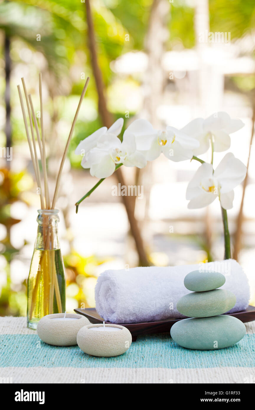 Spa and wellness massage setting Still life with candle, towel and stones  Outdoor summer background Stock Photo - Alamy