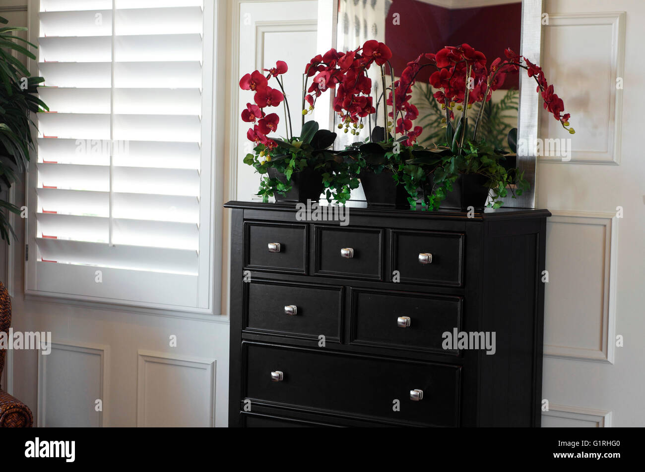 Bedroom window treatment - wood shutters and stylish drawers Stock Photo