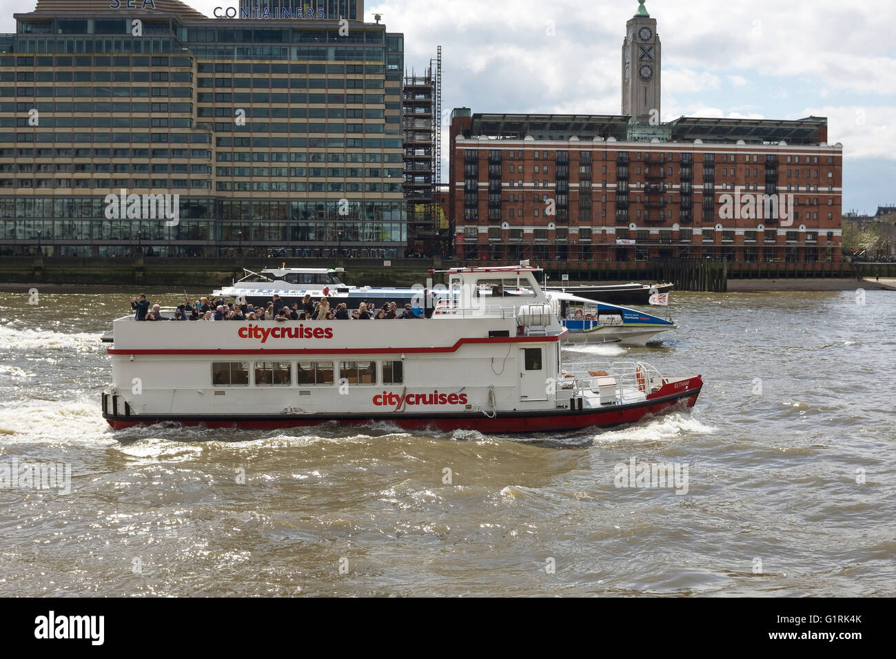 Two passenger boats on the River Thames pass the Oxo Tower, London UK Stock Photo