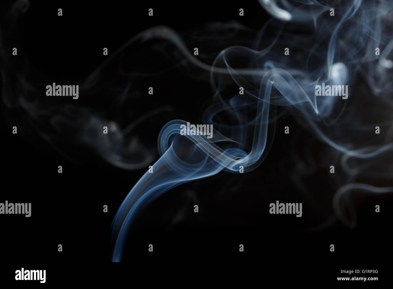 Abstract art. Color blue smoke from the aromatic sticks on a black