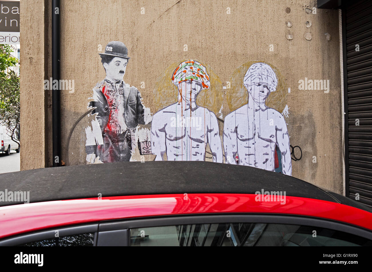 Street art graffiti seen over the top of a car roof. Stock Photo