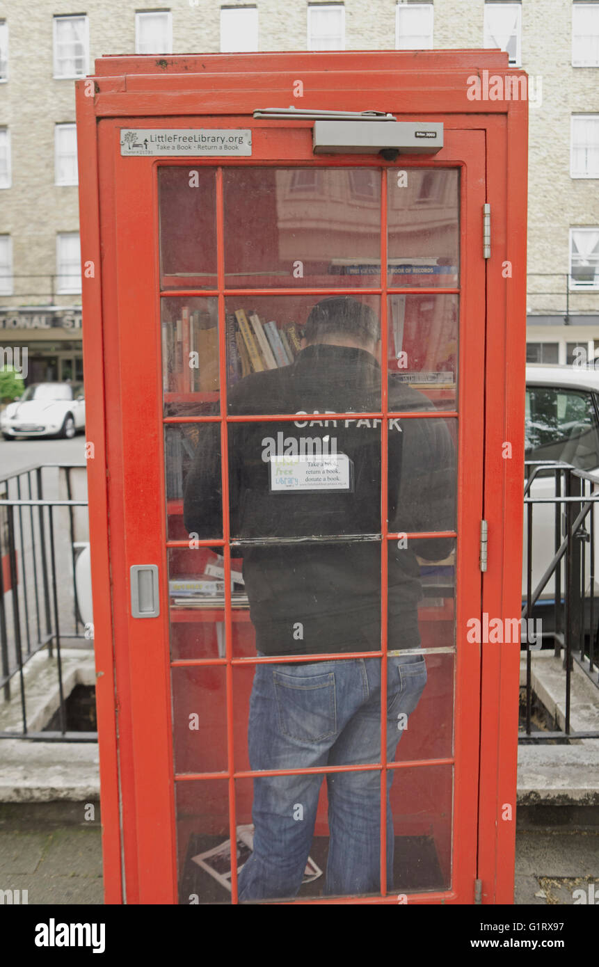 Telephone box library in use, London. Stock Photo