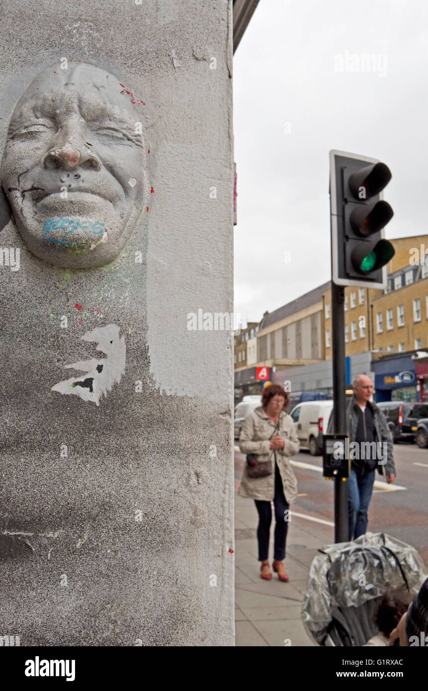 Gregos face mask on a wall in Camden High Street. Stock Photo