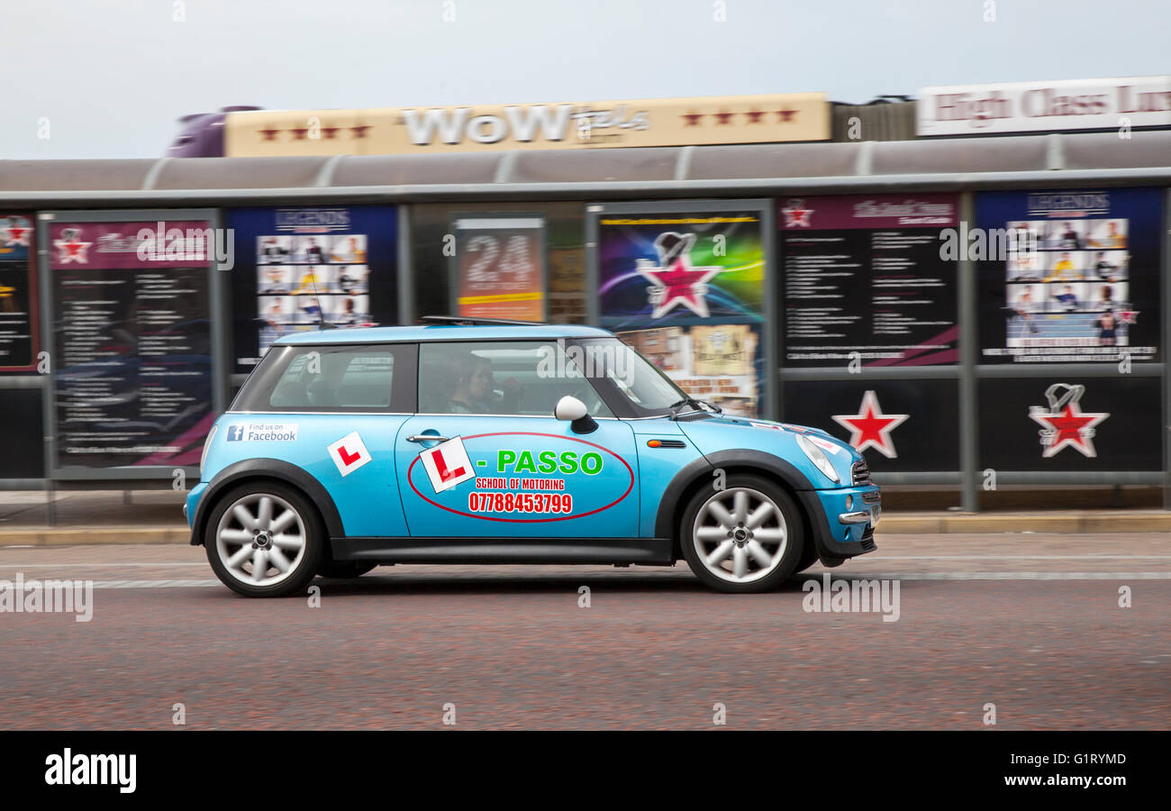 Passo Driving School Mini; Learner driver motorway training, under instruction, driving school, drivers, motorway driving lessons, approved driving instructor, supervised tution, instructor; Vehicular traffic L plates on moving vehicles, driving vehicle on UK roads, motors, motoring vehicle in motion being driven along the seafront at Blackpool, Lancashire, UK. Stock Photo