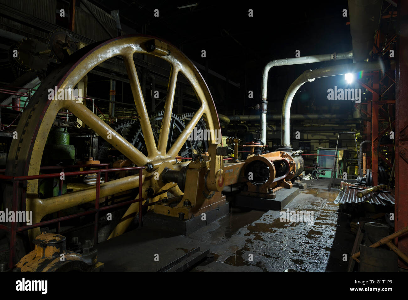 Giant  flywheel in old colonial factory in the night Stock Photo