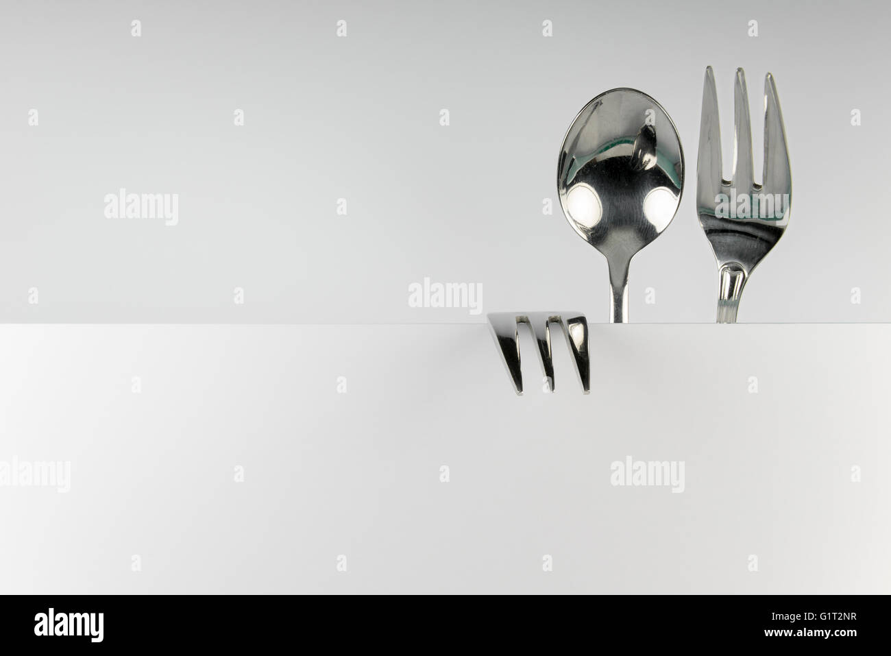 Metal spoon and two forks formed into conceptual fantasy figure Stock Photo
