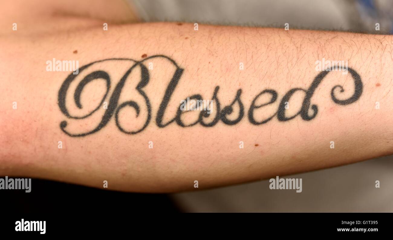 A blessed tattoo on a mans arm. Stock Photo