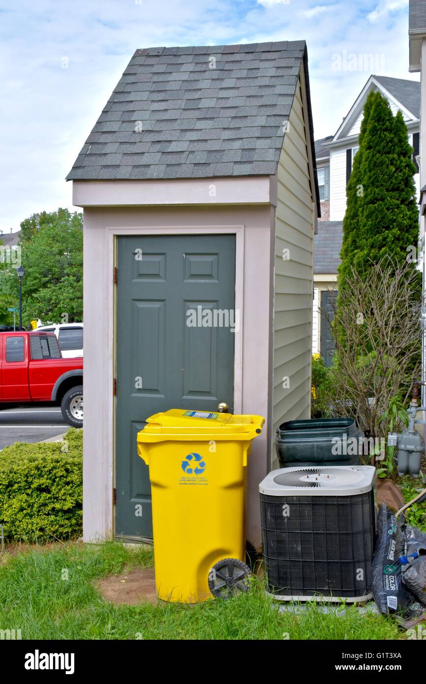 A yellow recycling bin outside a residential home in Anne Arundel