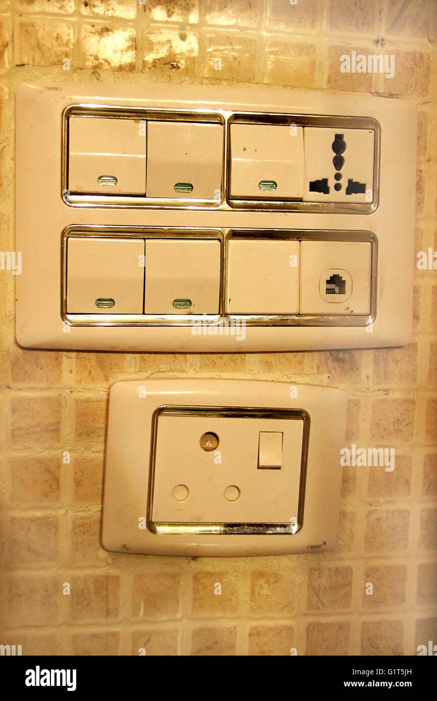 Grand, light brown, wall panels housing electrical switches, plug points, phone socket and indicators Stock Photo