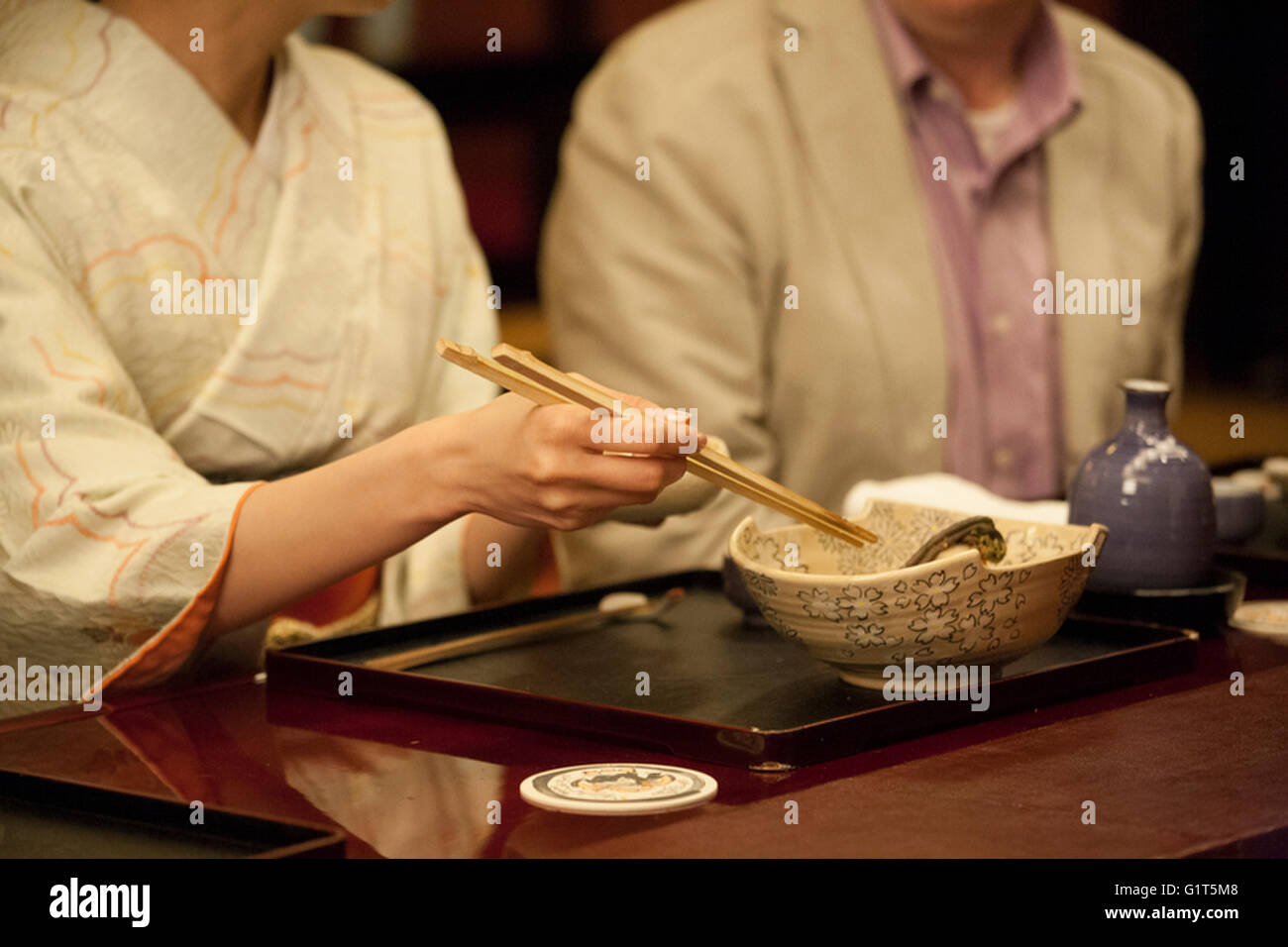 Woman eating Japanese dishes with chopsticks Stock Photo