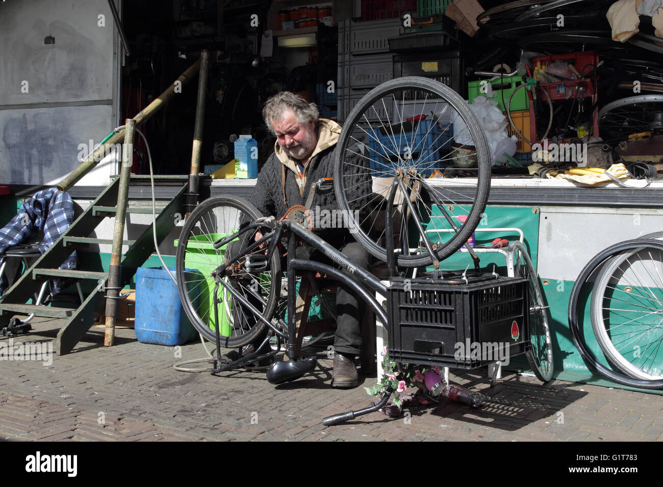Man repairing bicycle in his repair shop on the Waterlooplein Market in Amsterdam, Netherlands, Europe. Stock Photo