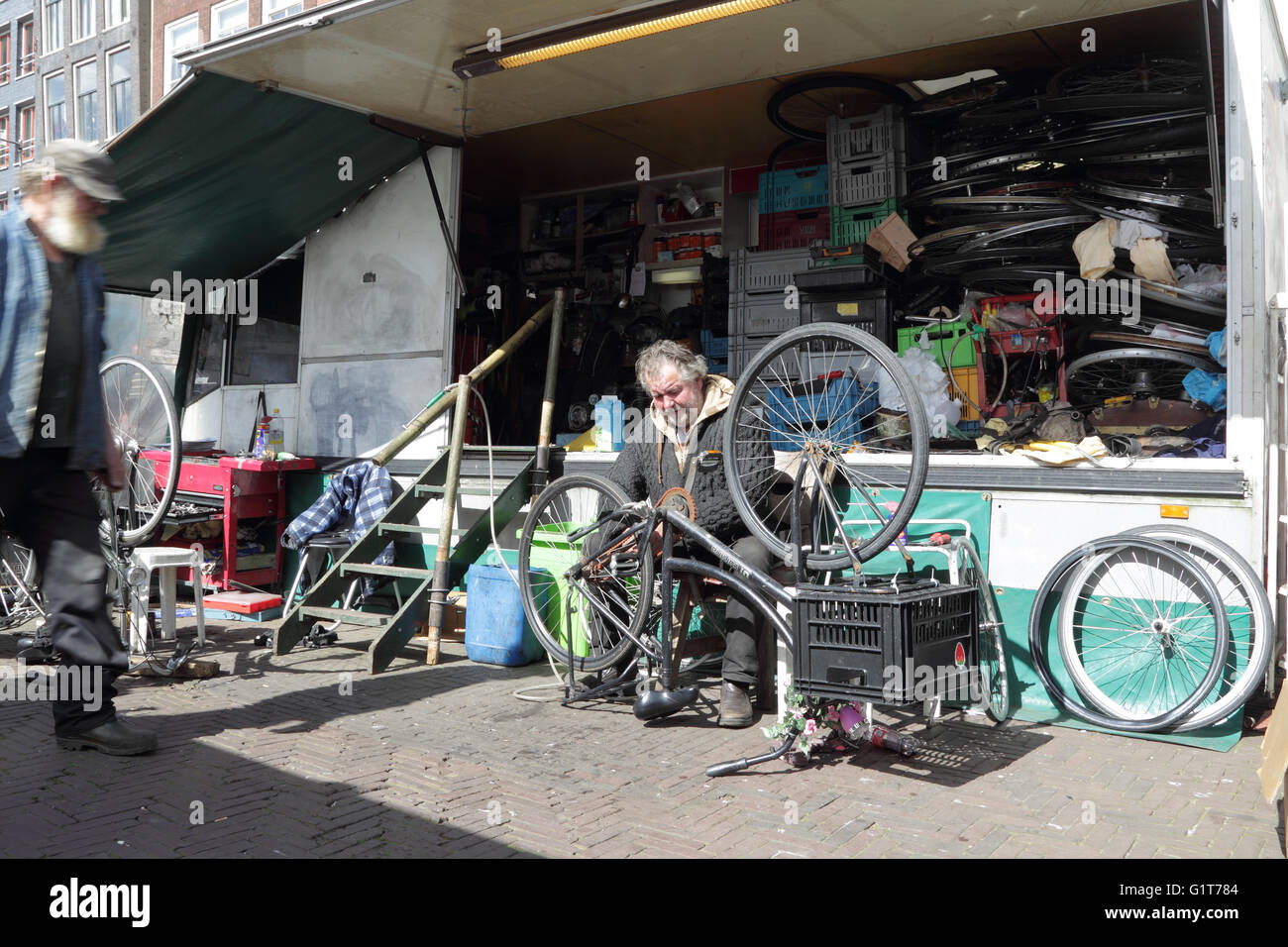 Man repairing bicycle in his repair shop on the Waterlooplein Market in Amsterdam, Netherlands, Europe. Stock Photo