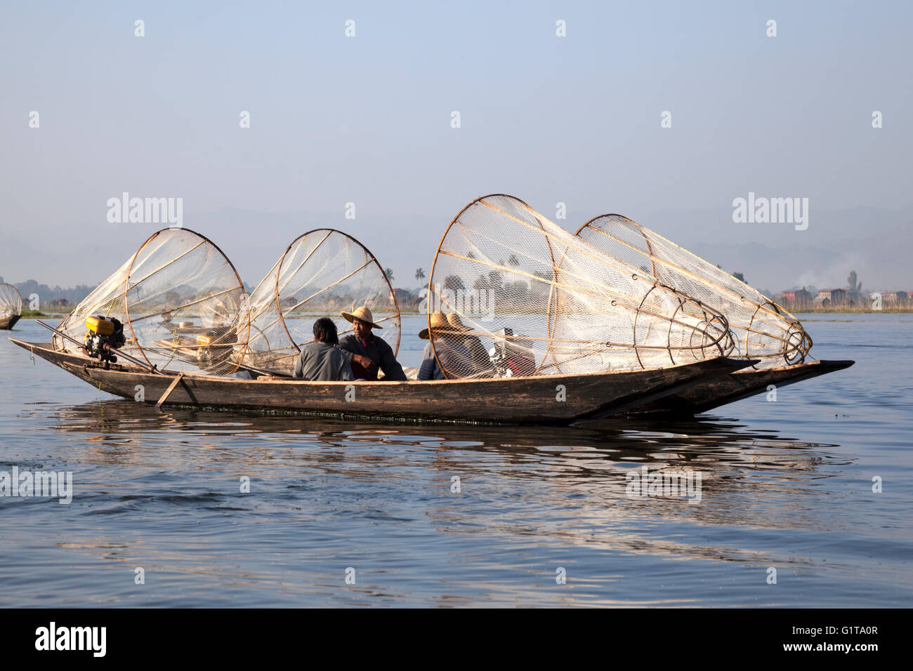 On the Inle Lake, two motorized pirogues anchored side by side with fishermen resting a while (Myanmar). Stock Photo