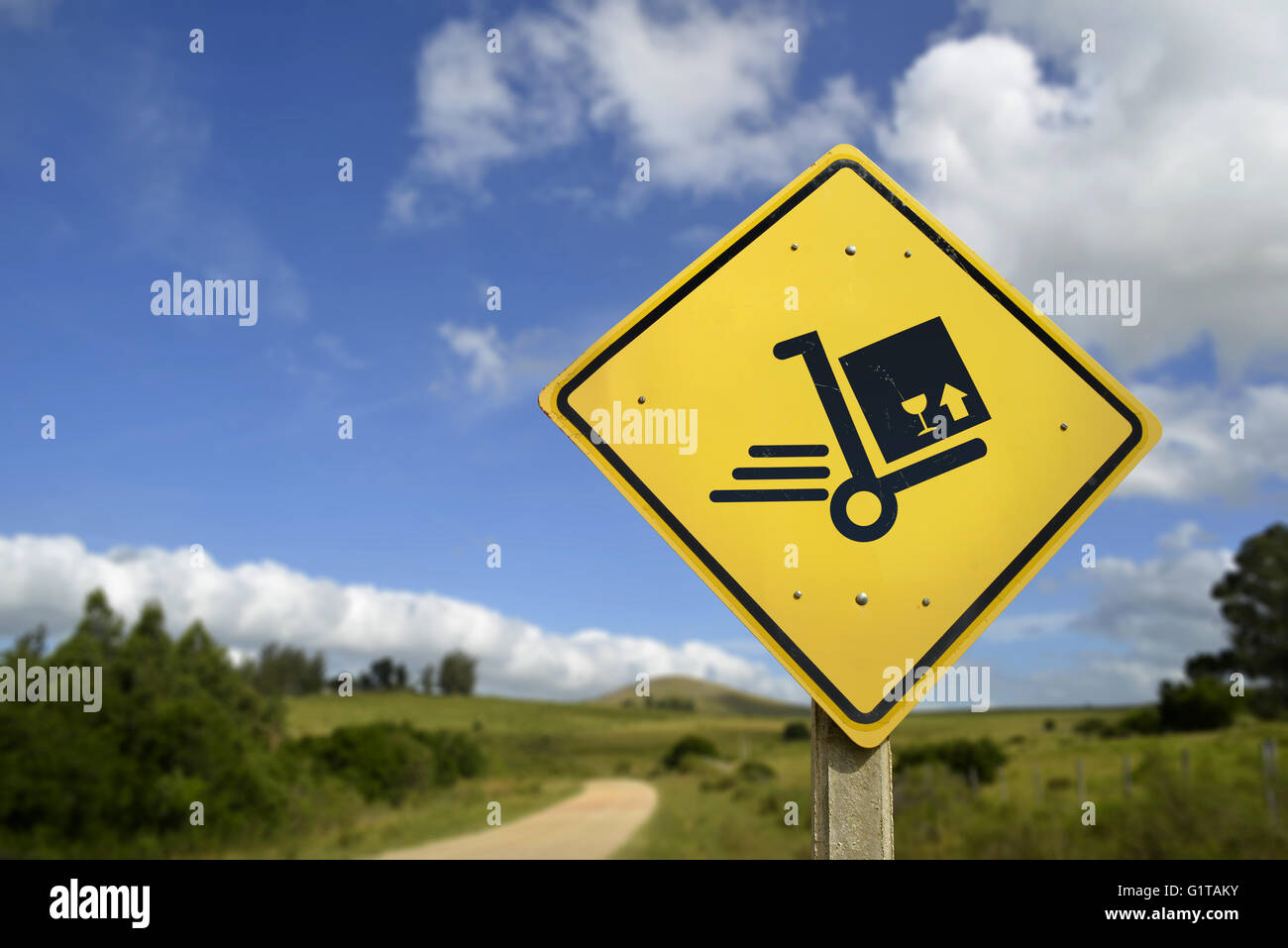Fast shipping service everywhere; package box concept. Road sign with delivery cart icon in rural landscape; includes copy space Stock Photo