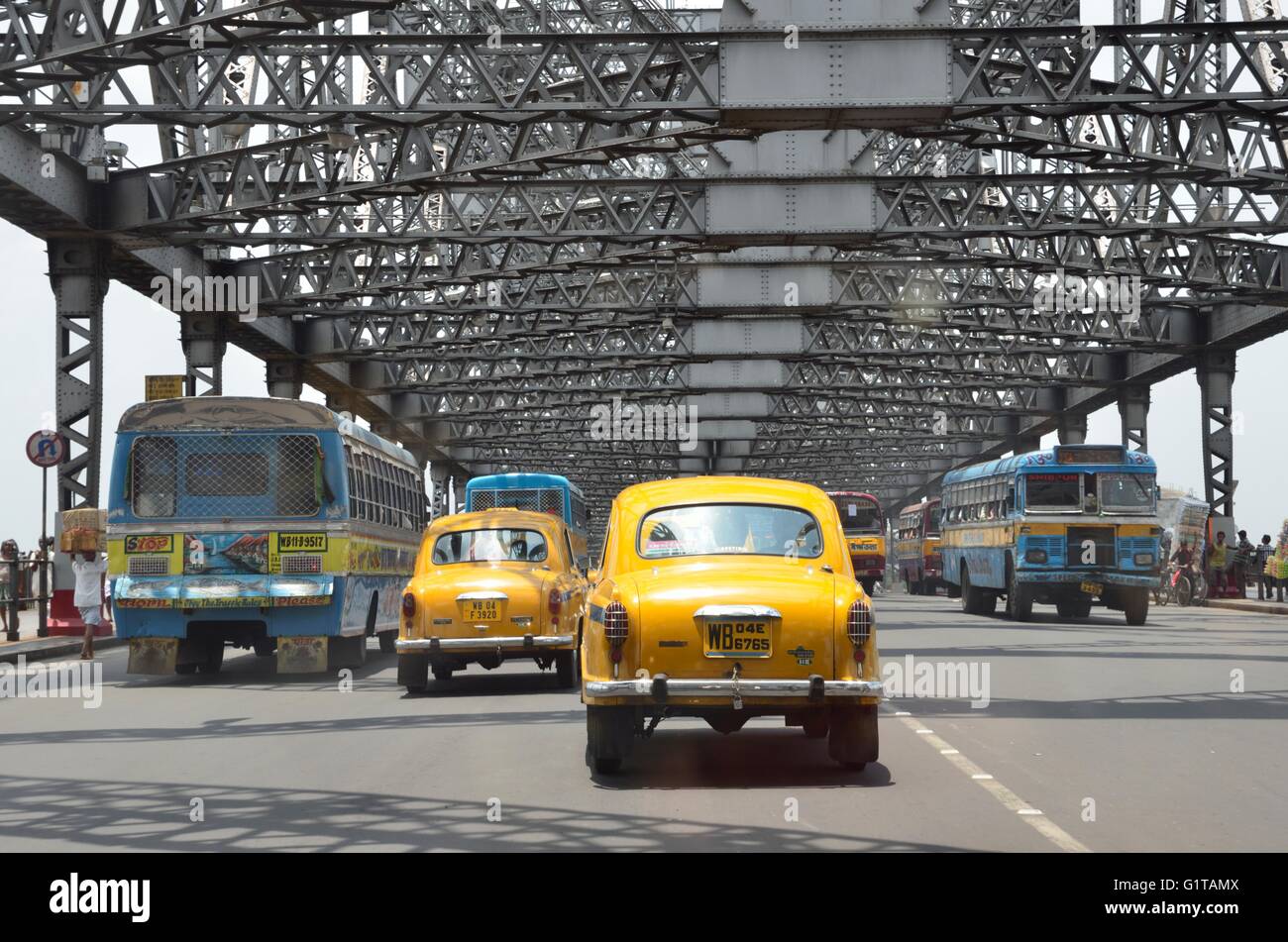 Rush hour traffic with local buses and ambassador taxi over Howrah Bridge, Kolkata, West Bengal, India Stock Photo