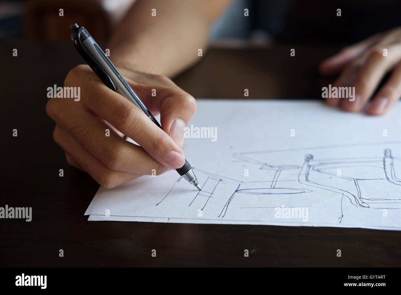 Hand of designer with his pen, designing and sketching his idea on sketchbook Stock Photo