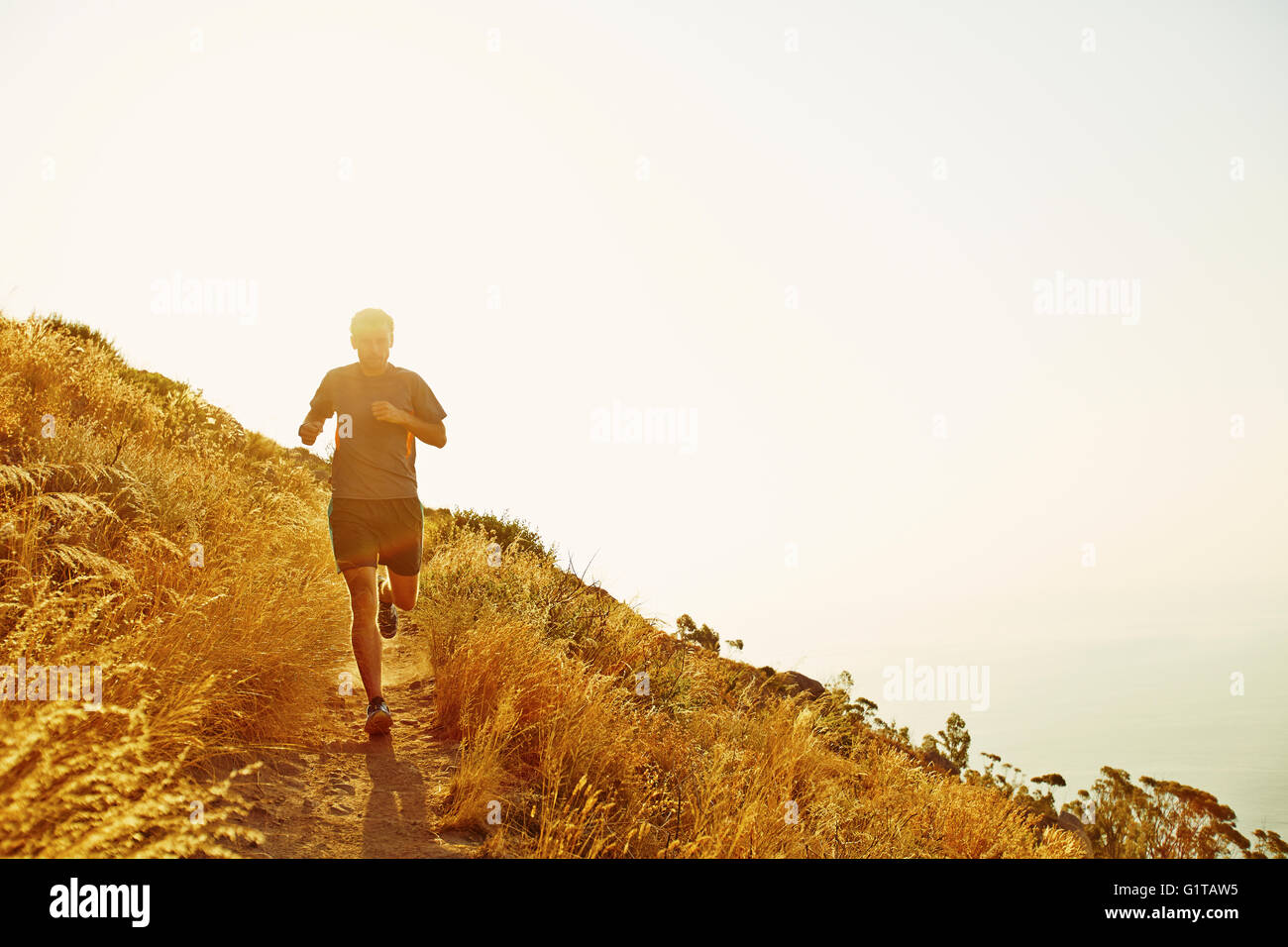 Man running on sunset trail Stock Photo