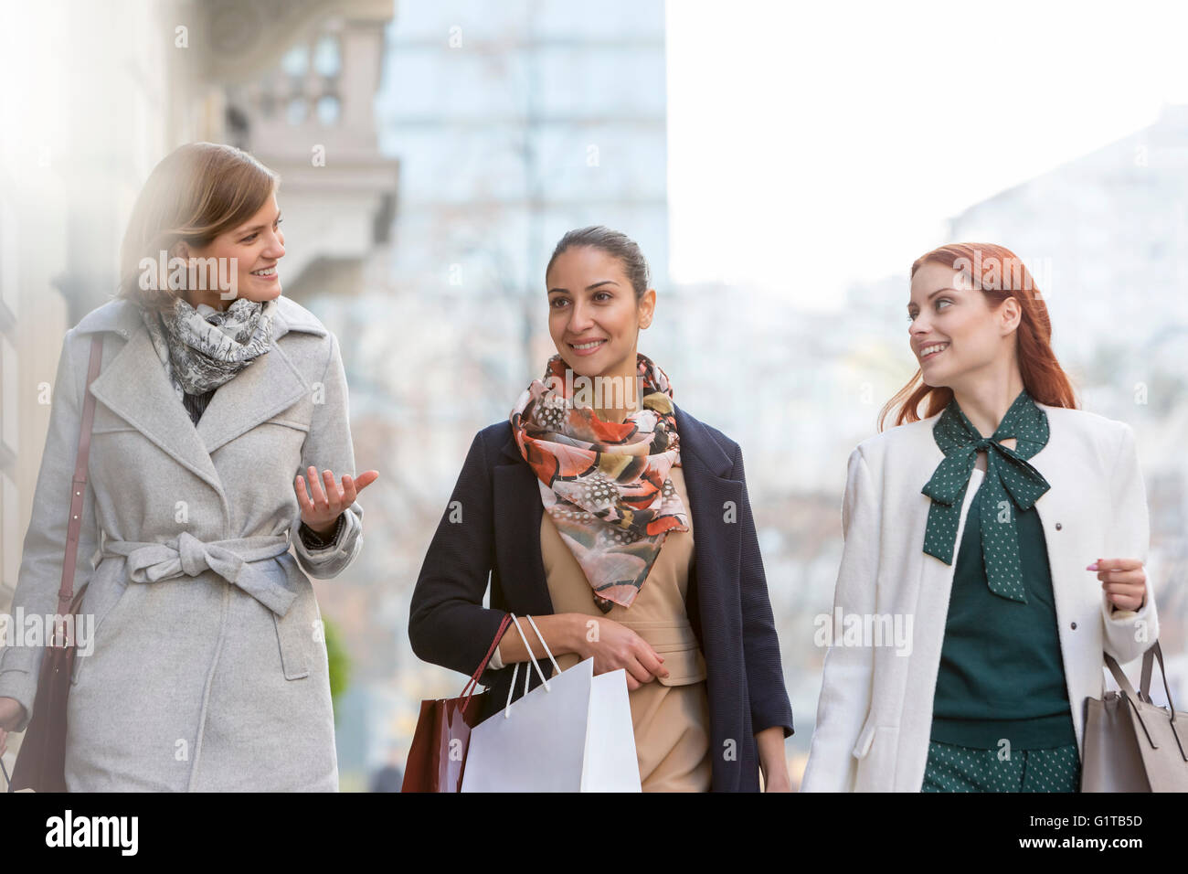 Women with shopping bags talking and walking in city Stock Photo