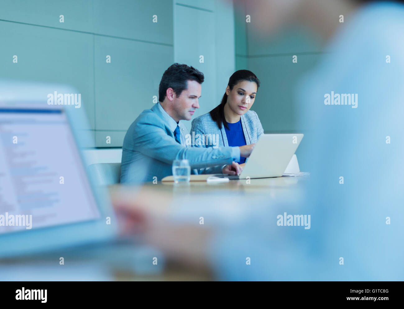 Business people working at laptop in conference room Stock Photo