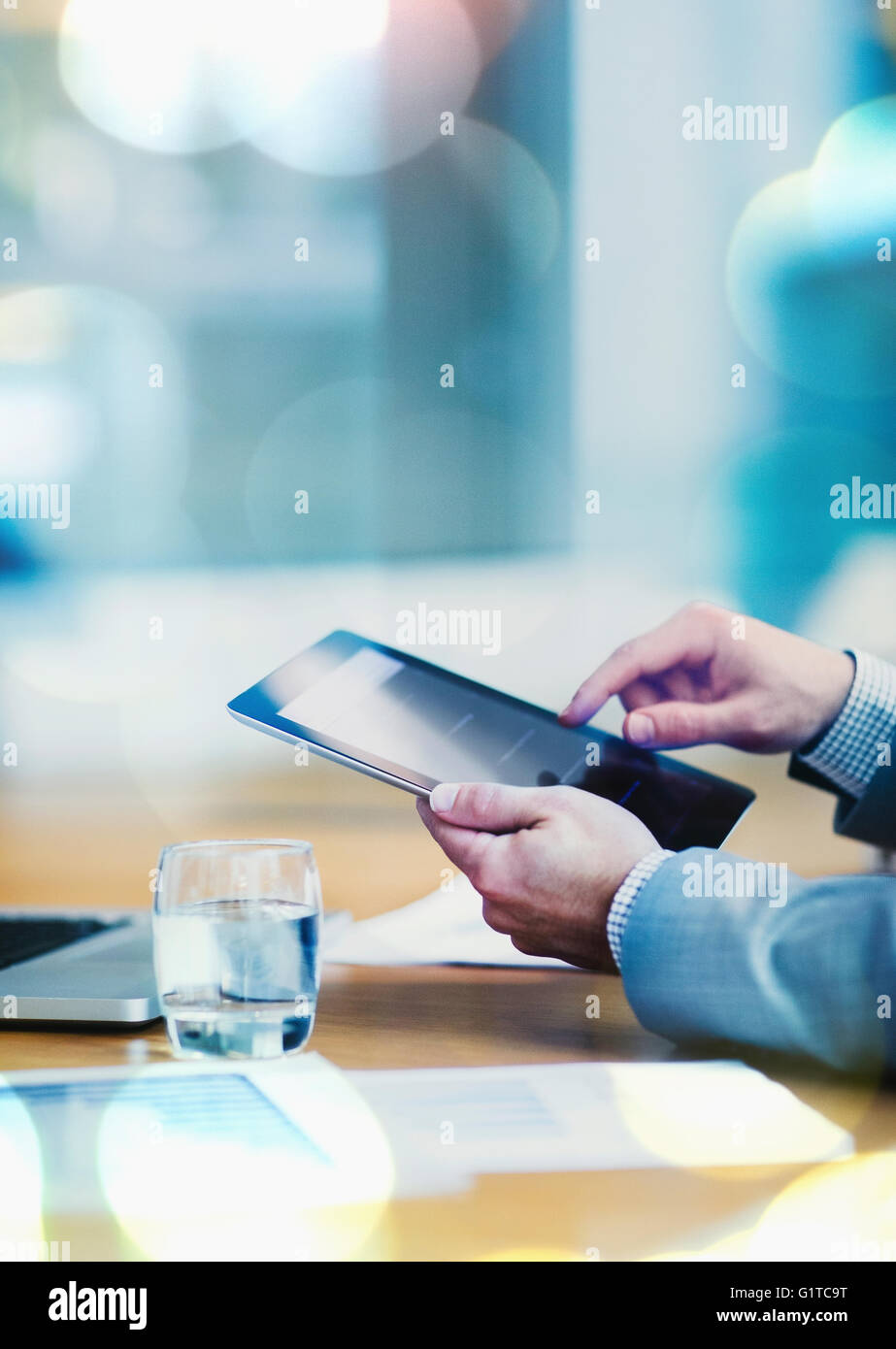 Businessman using digital tablet at conference table Stock Photo