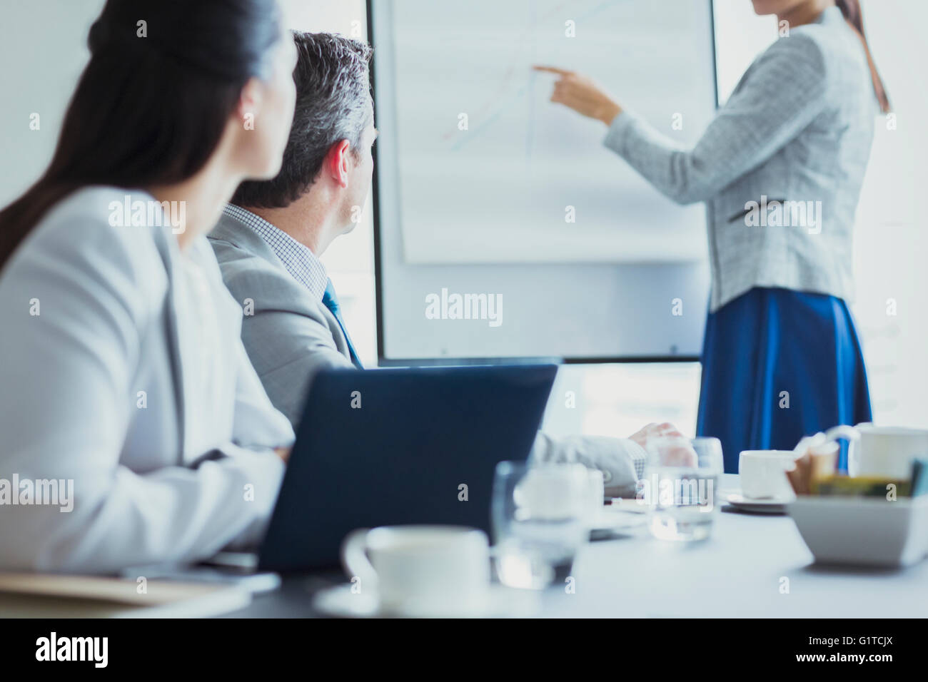 Businesswoman leading meeting at flip chart in conference room Stock Photo