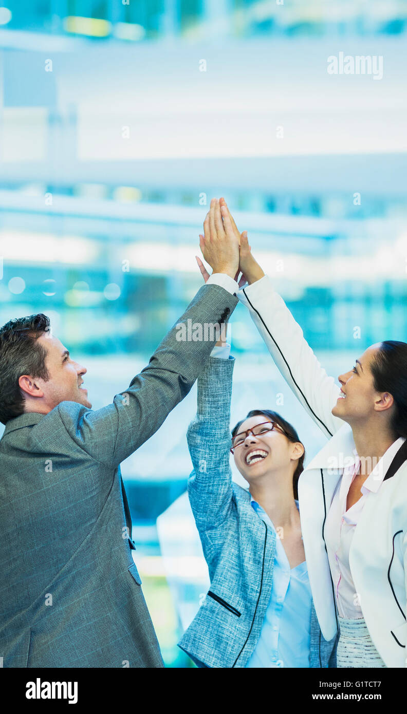 Enthusiastic business people with arms raised in office Stock Photo