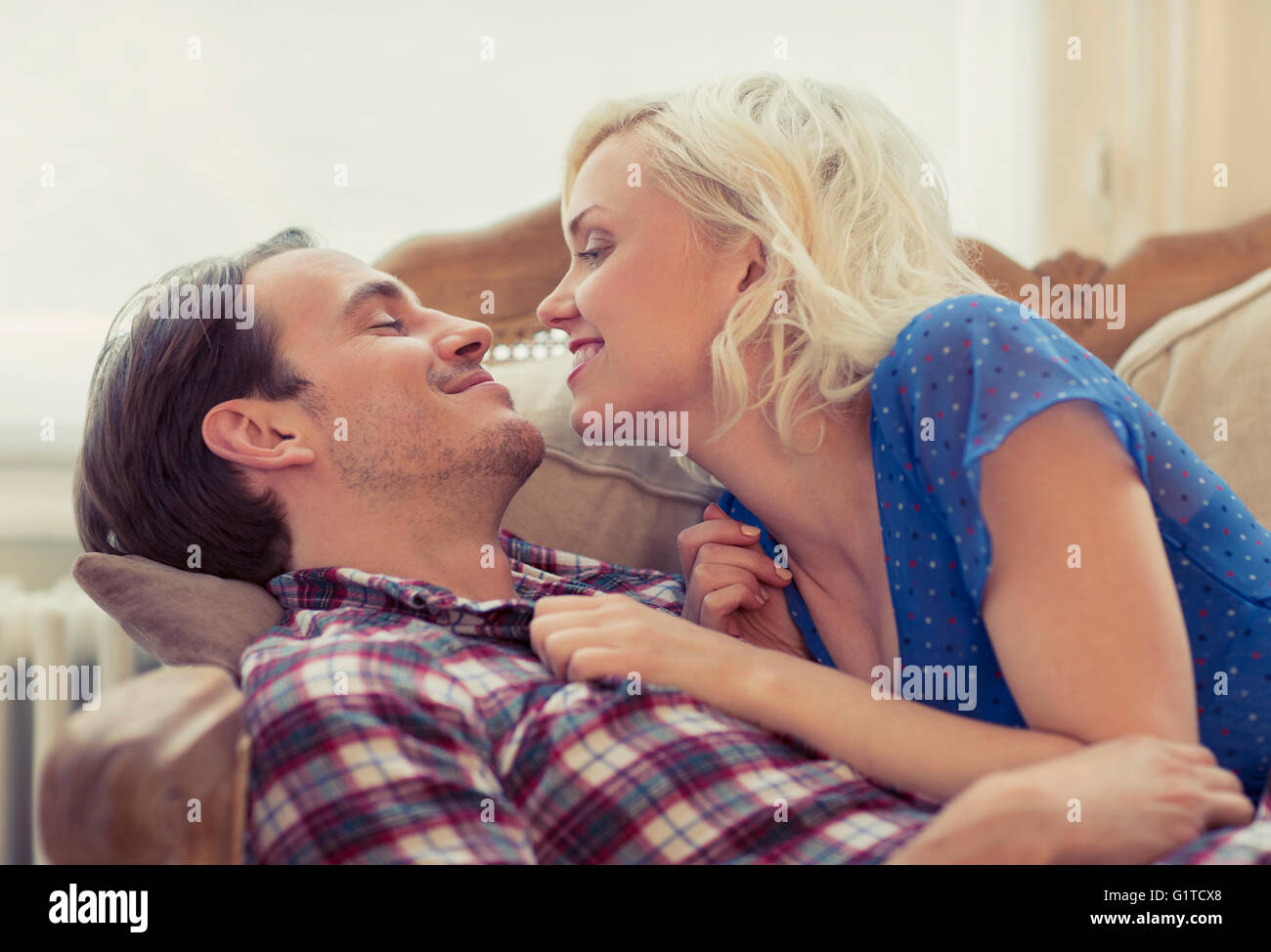 Affectionate couple laying on sofa Stock Photo