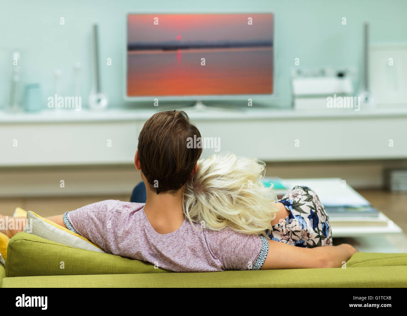 Relaxed couple watching TV on living room sofa Stock Photo