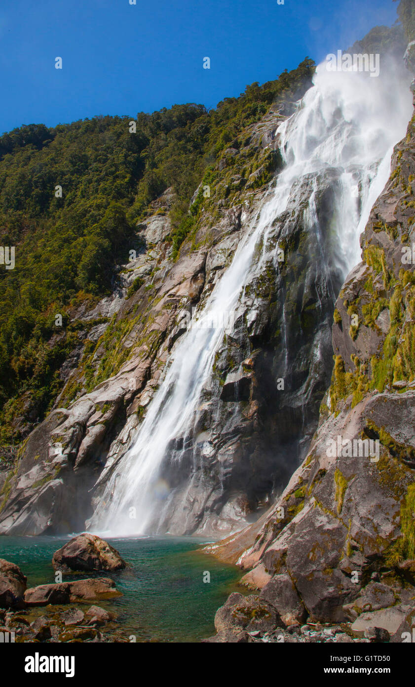 Waterfall flowing down mountain in Milford Sound fjord, Fjiordland ...