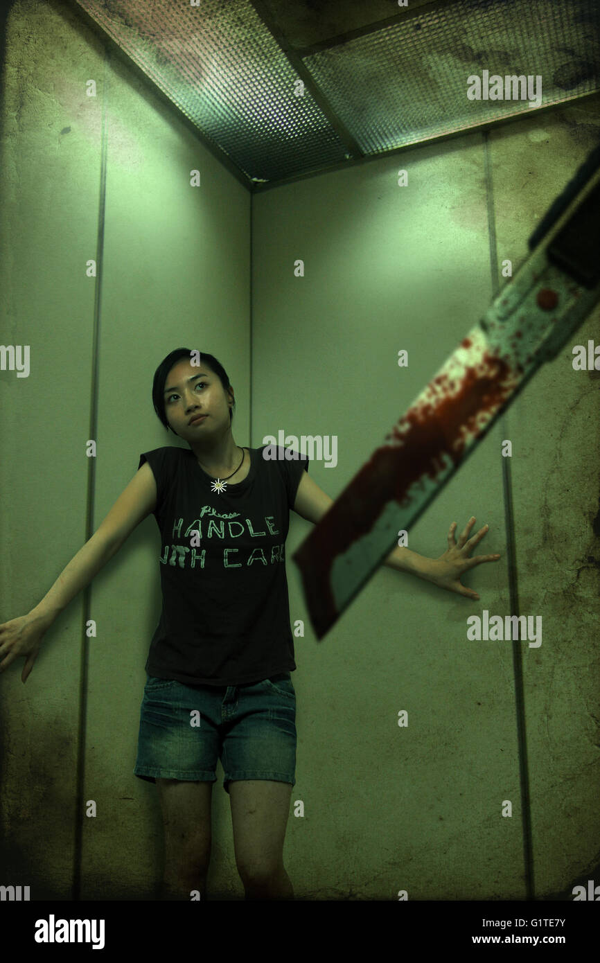 a girl in the lift treat from a cutter chinese ghost story horrible scare dream Stock Photo