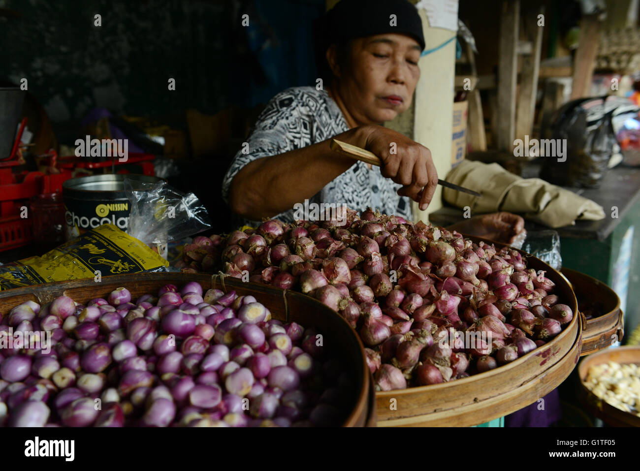 A Javanese woman peeling shallots in a market in Yogyakarta. Stock Photo