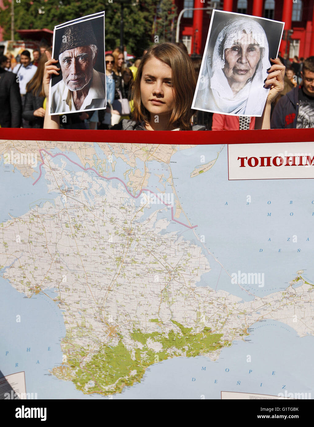 Kiev, Ukraine. 18th May, 2016. An Ukrainian student stands in front the Crimea map and holds portraits of Crimean Tatars during a rally dedicated to 72nd anniversary of Crimean Tatars deportation from the Crimea in 1944 by Soviet dictator Joseph Stalin, in Kiev, Ukraine, 18 May 2016. © Serg Glovny/ZUMA Wire/Alamy Live News Stock Photo