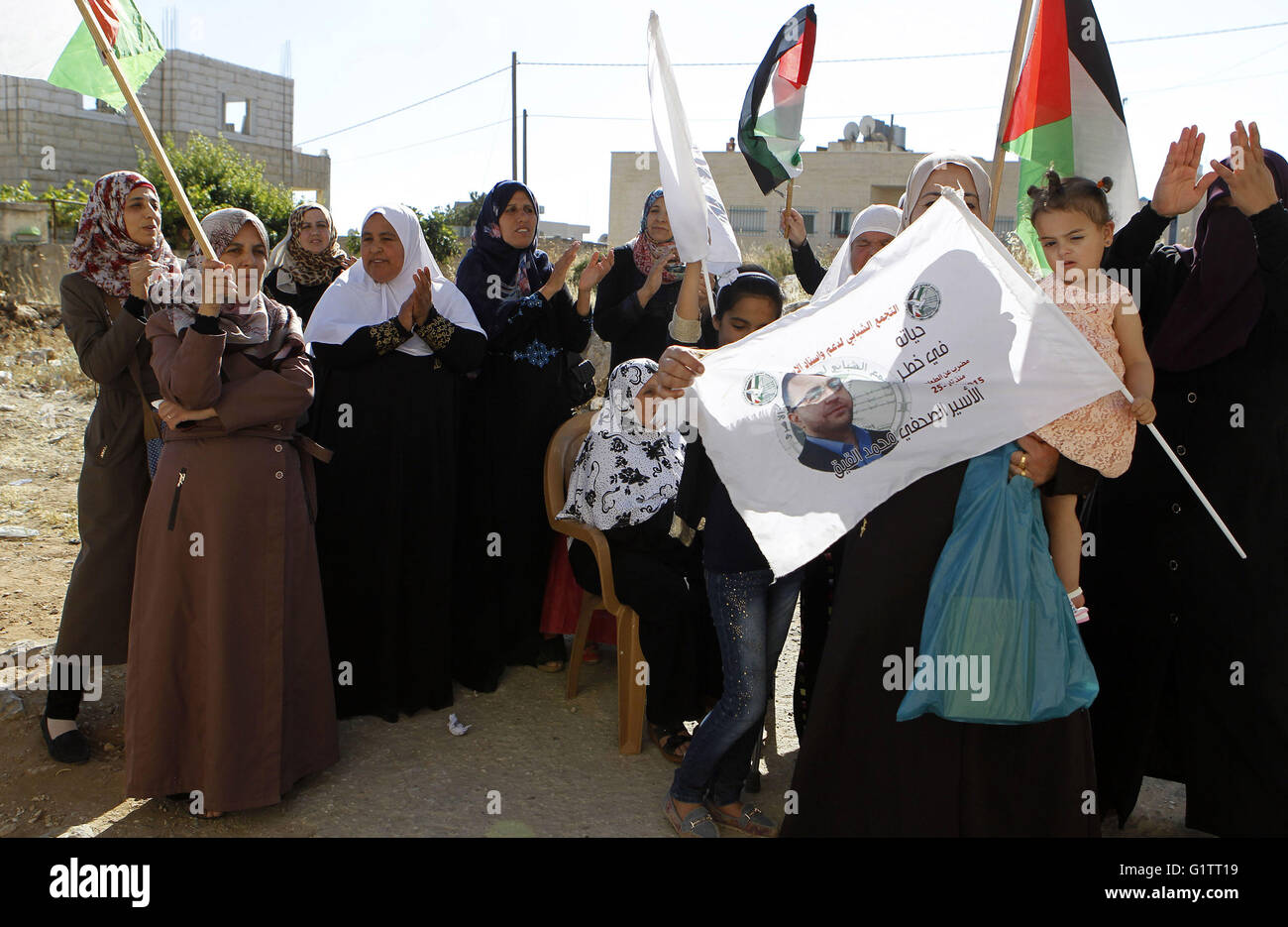 Hebron, West Bank, Palestinian Territory. 19th May, 2016. Palestinians wave national flags on May 19, 2016 in the southern West Bank village of Dura, as they wait for the arrival of Palestinian imprisoned journalist, Mohammed al-Qiq, after he was released from the Israeli Nafha Prison. Mohammed al-Qiq, 33, held by Israel without trial, agreed on February 26, 2016 to end his 94-day hunger strike under a deal for his release in May. Mohammed al-Qiq was released near the Jewish settlement of Beit Hagai, at the southern entrance to the occupied West Bank city of Hebron near his village (Credit Im Stock Photo