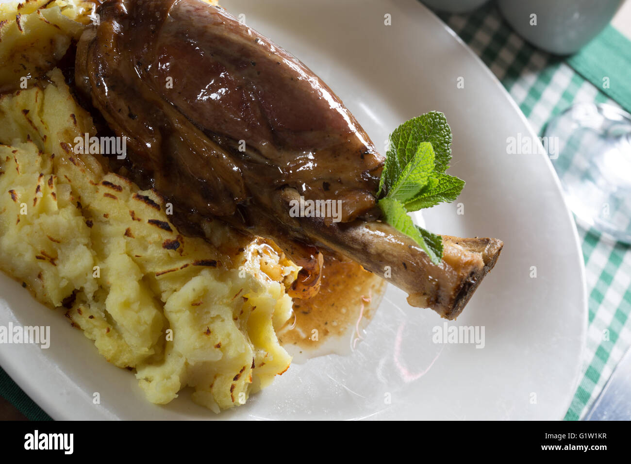 A serving of Lamb Shank with Mint gravy and Mashed Potato. Stock Photo