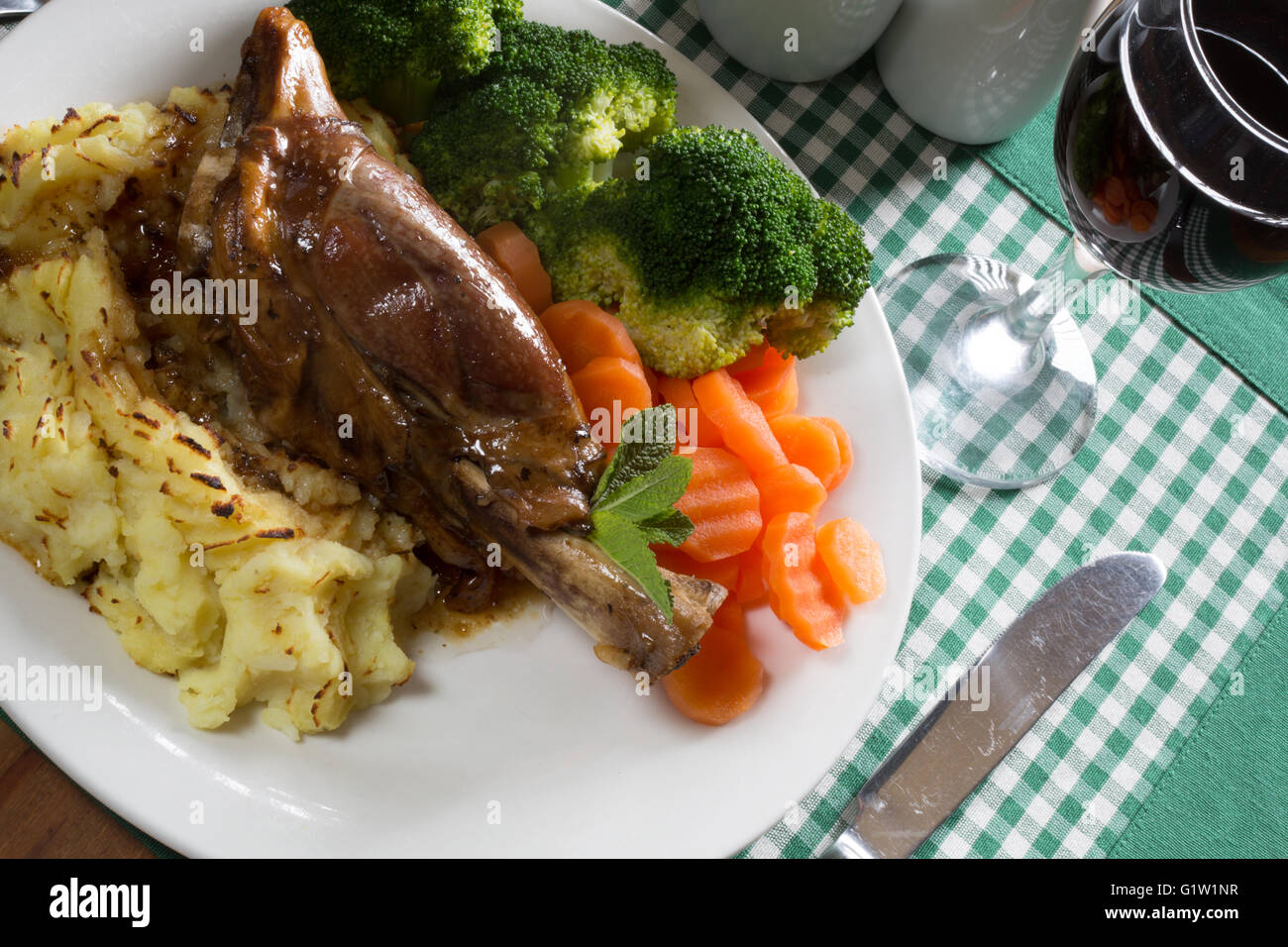 A serving of Lamb Shank with Mint gravy and Mashed Potato. Served with Vichy Carrots and Broccoli florets, Stock Photo