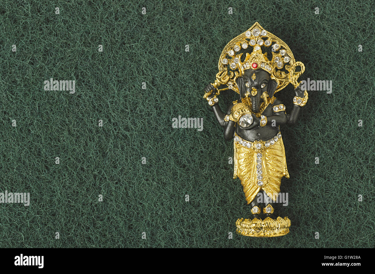 Small idol (miniature) of Lord Ganesha with the background of grass, Studio shot, Pune, Maharashtra, India Stock Photo