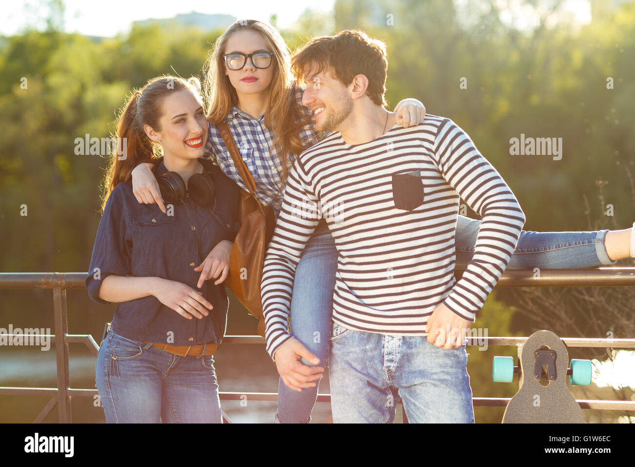 Friendship, leisure, summer, technology and people concept - smiling friends having fun outdoors Stock Photo