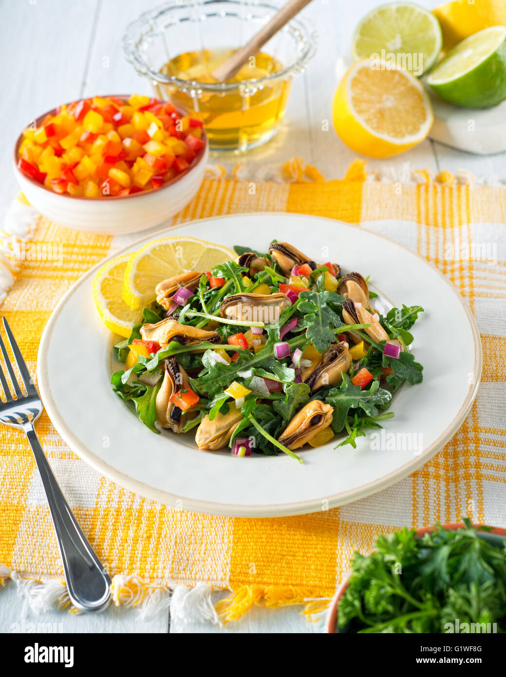 A delicious citrus honey mussel salad with arugula, peppers, lemon, and lime. Stock Photo