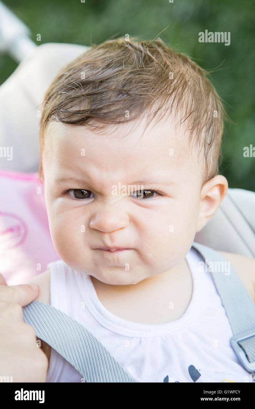 Portrait of funny one year old baby making faces while looking at camera Stock Photo