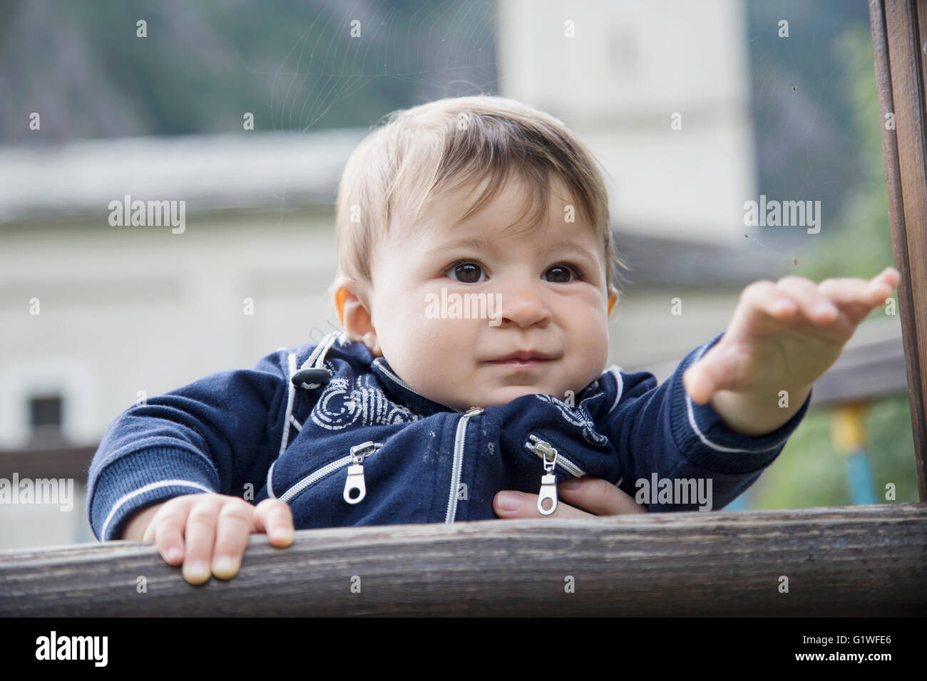 Portrait of cute one year old baby looking away and pulling arm Stock