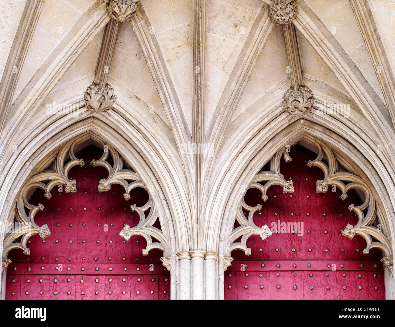 Perpendicular style arched doorways and vaulting above the red door at the west end of Winchester Cathedral, Hampshire Stock Photo