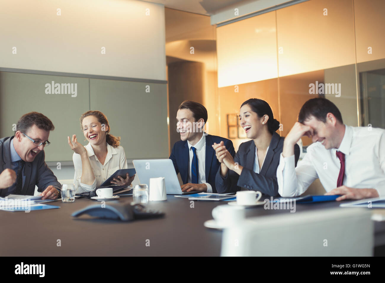 Business people laughing in conference room meeting Stock Photo