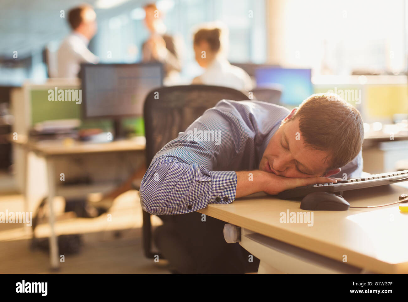Businessman sleeping on desk in office Stock Photo